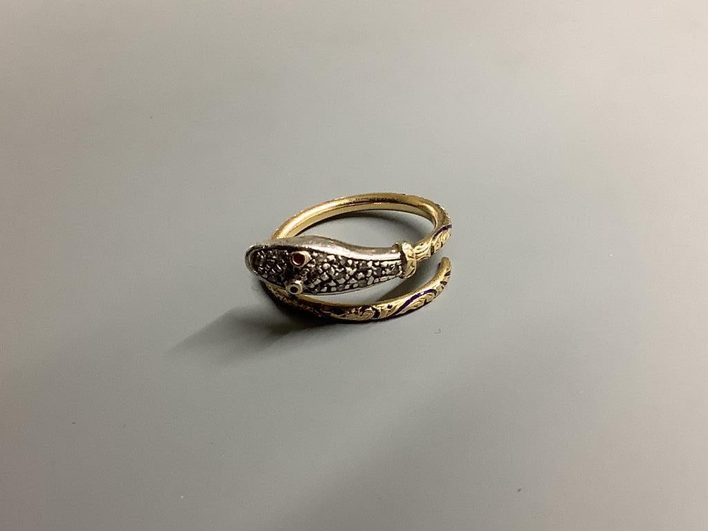 A yellow metal, blue enamel(a.f.) ruby and diamond chip set serpent ring, size L, gross 4.5 grams.